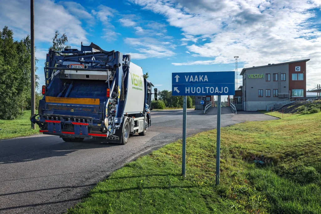 Jäteauto ajamassa kohti vaaka-asemaa. Oikeassa reunassa näkyy opastekyltti ja taustalla Vestian palvelurakennus